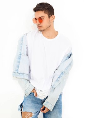 Yakışıklı genç model adam portresi beyaz arka plan üzerinde poz güneş gözlüğü kot elbise giymiş. İzole