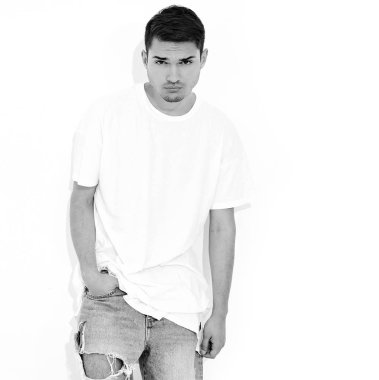 Yakışıklı genç model adam portresi kot elbise ve T-shirt beyaz arka plan üzerinde poz giyinmiş. Çapraz kollar