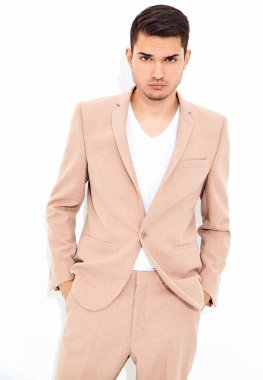 portre yakışıklı moda şık hipster lumbersexual işadamı modeli Studio beyaz duvarının yakınında poz zarif ışık pembe takım elbise giymiş. Metroseksüel