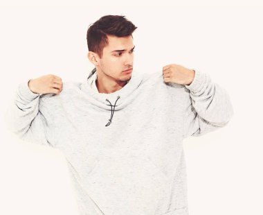 Beyaz arka plan üzerinde poz gri rahat Kapşonlu elbise giymiş genç yakışıklı modeli adam portresi. İzole