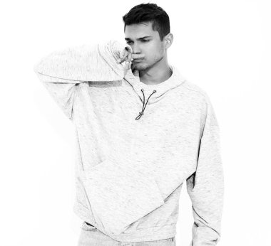 Beyaz arka plan üzerinde poz gri rahat Kapşonlu elbise giymiş genç yakışıklı modeli adam portresi. İzole