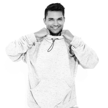Yakışıklı model adam gülümseyen genç portresi beyaz arka plan üzerinde poz gri rahat Kapşonlu elbise giymiş. İzole