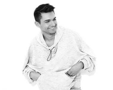 Yakışıklı model adam gülümseyen genç portresi beyaz arka plan üzerinde poz gri rahat Kapşonlu elbise giymiş. İzole