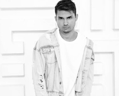 Genç yakışıklı modeli adam portresi dokulu beyaz duvara yakın poz gri rahat Kapşonlu elbise giymiş