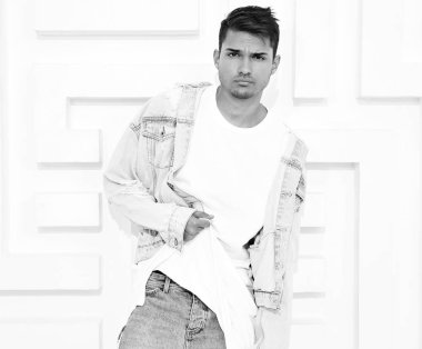 Genç yakışıklı modeli adam portresi dokulu beyaz duvara yakın poz gri rahat Kapşonlu elbise giymiş