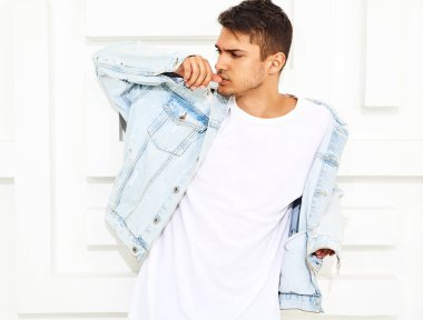 Yakışıklı genç model adam portresi beyaz dokulu duvar poz kot elbise giymiş