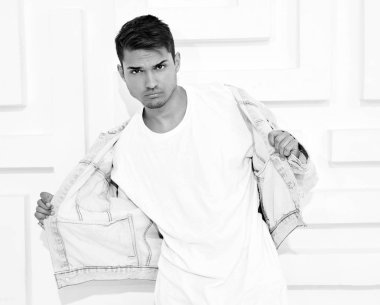 Genç yakışıklı modeli adam portresi dokulu beyaz duvara yakın poz gri rahat Kapşonlu elbise giymiş