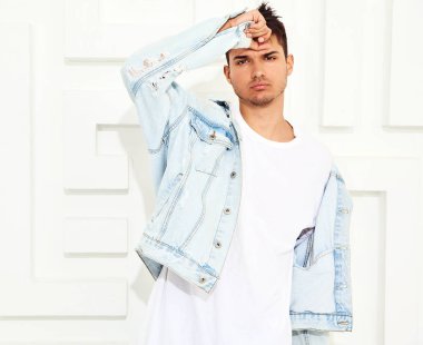 Yakışıklı genç model adam portresi beyaz dokulu duvar poz kot elbise giymiş