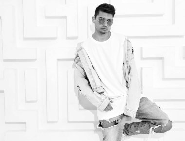 Yakışıklı genç model adam portresi beyaz dokulu duvar poz kot elbise giymiş