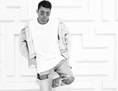 Yakışıklı genç model adam portresi beyaz dokulu duvar poz kot elbise giymiş