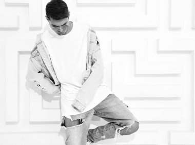 Yakışıklı genç model adam portresi beyaz dokulu duvar poz kot elbise giymiş