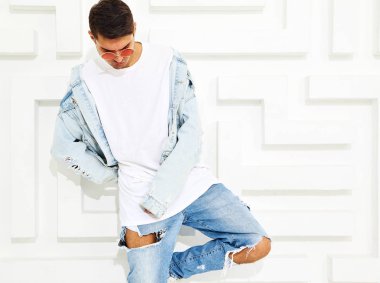 Yakışıklı genç model adam portresi beyaz dokulu duvar poz kot elbise giymiş