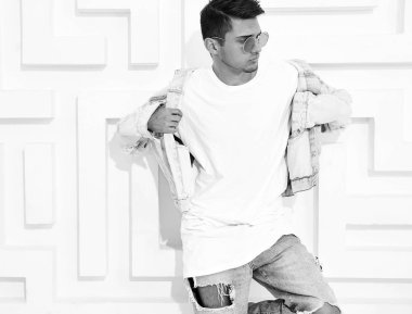 Yakışıklı genç model adam portresi beyaz dokulu duvar poz kot elbise giymiş