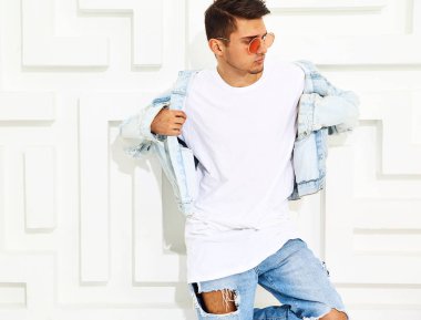 Yakışıklı genç model adam portresi beyaz dokulu duvar poz kot elbise giymiş