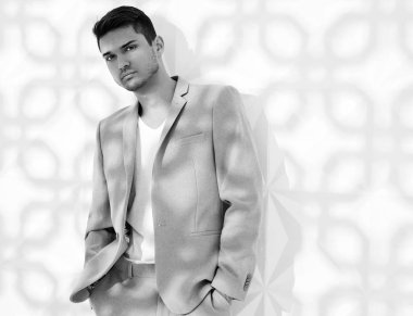 Moda şık lumbersexual modeli Studio beyaz duvarının yakınında poz zarif ışık pembe takım elbise giymiş. Metroseksüel