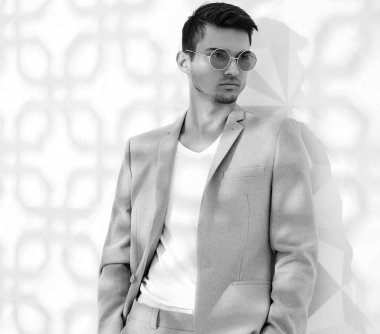 Moda şık lumbersexual modeli Studio beyaz duvarının yakınında poz zarif ışık pembe takım elbise giymiş. Metroseksüel