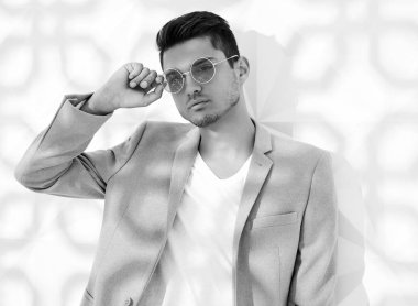 Moda şık lumbersexual modeli Studio beyaz duvarının yakınında poz zarif ışık pembe takım elbise giymiş. Metroseksüel