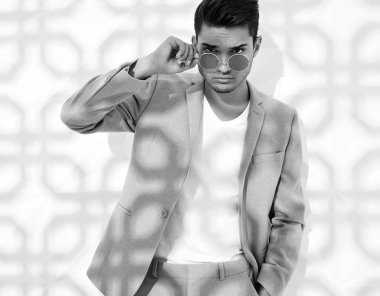 Moda şık lumbersexual modeli Studio beyaz duvarının yakınında poz zarif ışık pembe takım elbise giymiş. Metroseksüel