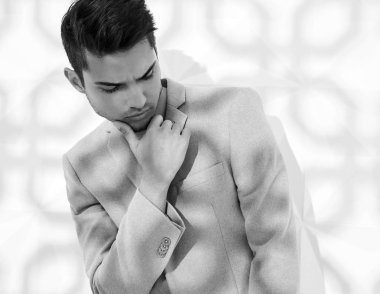 Moda şık lumbersexual modeli Studio beyaz duvarının yakınında poz zarif ışık pembe takım elbise giymiş. Metroseksüel