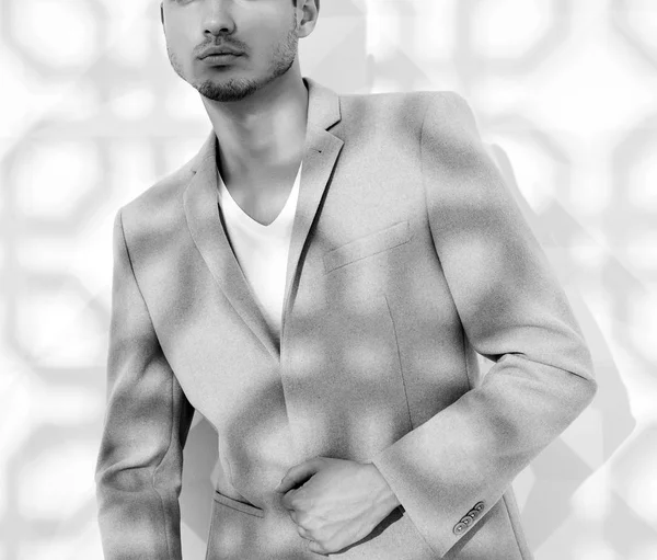 Moda şık lumbersexual modeli Studio beyaz duvarının yakınında poz zarif ışık pembe takım elbise giymiş. Metroseksüel