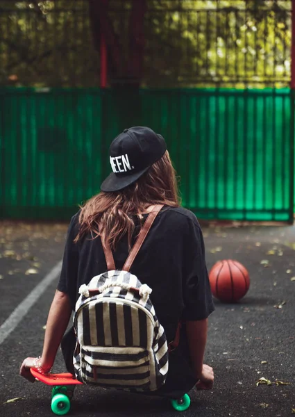 Plastik Turuncu Penny Shortboard Şapkalı Asfalt Üzerinde Oturan Genç Kız — Stok fotoğraf