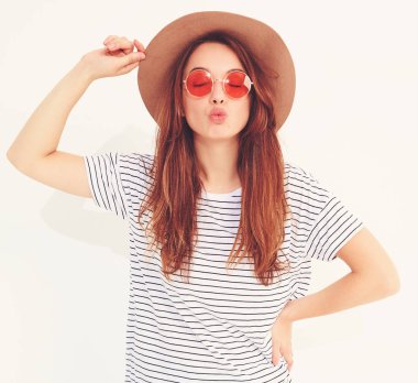 Genç şık gülen kız modeli rahat yaz giysileri ile doğal makyaj beyaz arka plan üzerinde izole kahverengi şapkalı portresi. Hava öpücük vererek