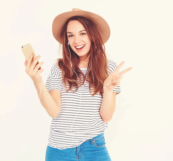 Portrait of a pretty girl in summer hipster clothes taking a selfie isolated on white background. showing peace sign