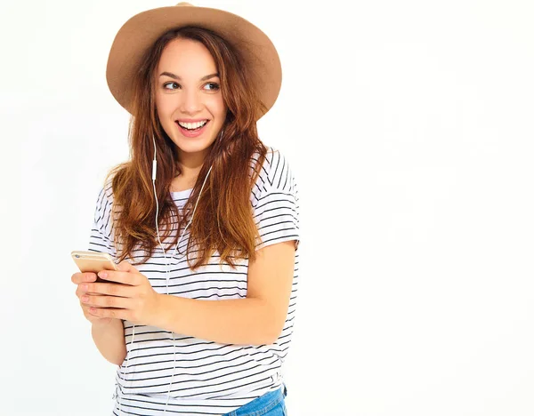 hiç makyaj smartphone üzerinde beyaz izole kulaklık ile kahverengi şapka dinleme müzik ile güzel kız rahat hipster yaz giysileri. Dans