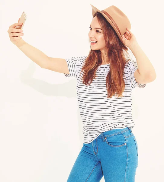 Portrait of a pretty girl in summer hipster clothes taking a selfie isolated on white background