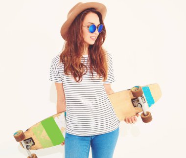 Portre rahat yaz giysileri longboard resepsiyon ile poz kahverengi şapkalı şık kız modeli. Beyaz izole