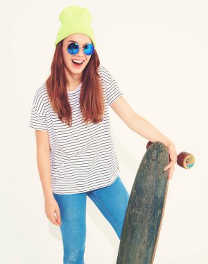 Portre rahat yaz giysileri longboard resepsiyon ile poz sarı beanie şapkalı şık kız modeli. Beyaz izole