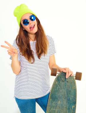 Portre rahat yaz giysileri longboard resepsiyon ile poz sarı beanie şapkalı şık kız modeli. Beyaz izole