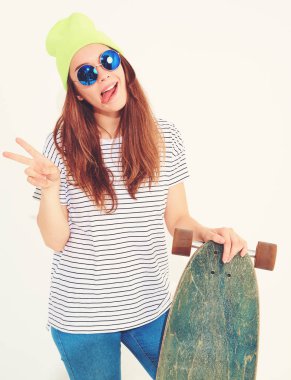 Portre rahat yaz giysileri longboard resepsiyon ile poz sarı beanie şapkalı şık kız modeli. Beyaz izole