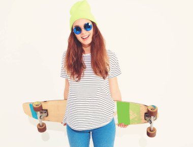 Portre rahat yaz giysileri longboard resepsiyon ile poz sarı beanie şapkalı şık kız modeli. Beyaz izole