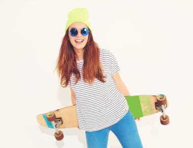 Portre rahat yaz giysileri longboard resepsiyon ile poz sarı beanie şapkalı şık kız modeli. Beyaz izole