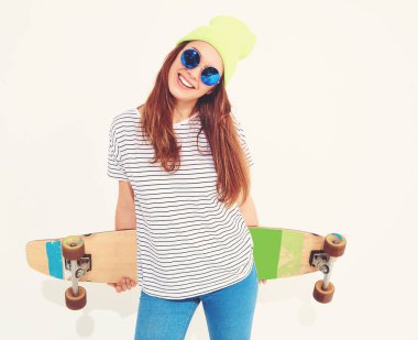 Portre rahat yaz giysileri longboard resepsiyon ile poz sarı beanie şapkalı şık kız modeli. Beyaz izole