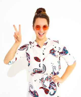 Gülümseyen kız modeli rahat yaz giysileri güneş gözlüğü. Göz kırpıyor ve barış işareti gösterilen