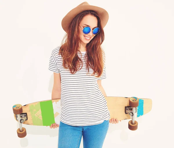 Portre rahat yaz giysileri longboard resepsiyon ile poz kahverengi şapkalı şık kız modeli. Beyaz izole