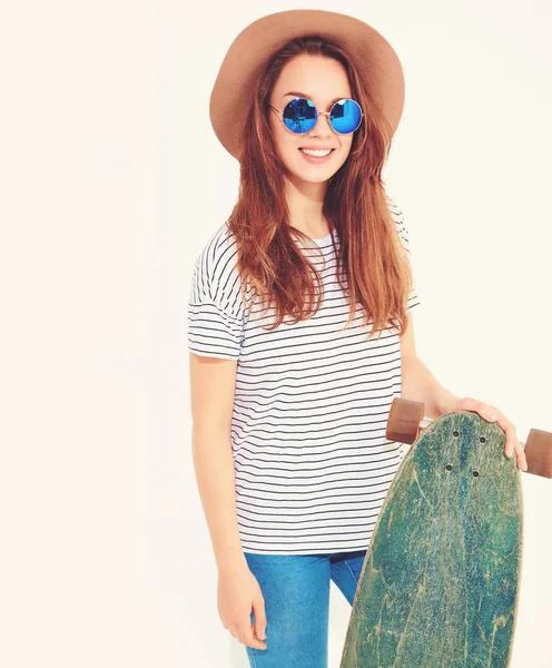 Portre rahat yaz giysileri longboard resepsiyon ile poz kahverengi şapkalı şık kız modeli. Beyaz izole