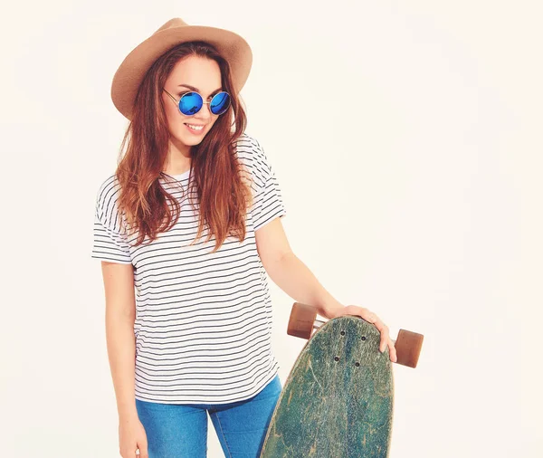 Portre rahat yaz giysileri longboard resepsiyon ile poz kahverengi şapkalı şık kız modeli. Beyaz izole