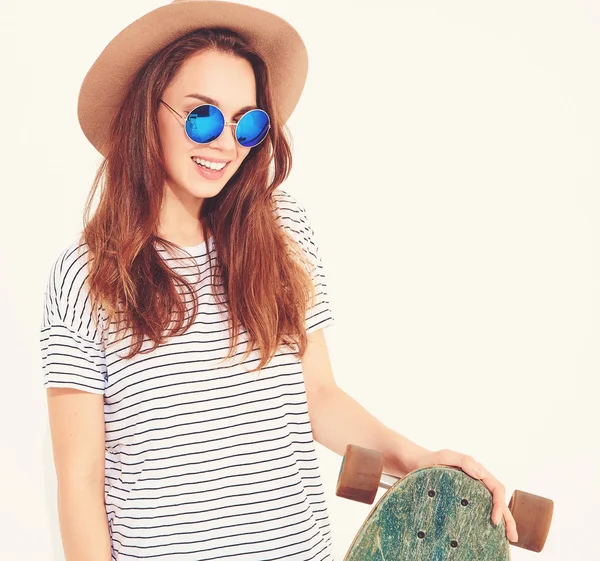 Portre rahat yaz giysileri longboard resepsiyon ile poz kahverengi şapkalı şık kız modeli. Beyaz izole