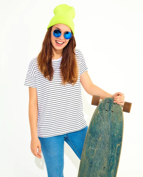 Portre rahat yaz giysileri longboard resepsiyon ile poz sarı beanie şapkalı şık kız modeli. Beyaz izole