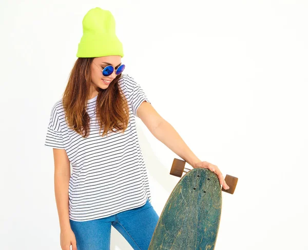 Portre rahat yaz giysileri longboard resepsiyon ile poz sarı beanie şapkalı şık kız modeli. Beyaz izole