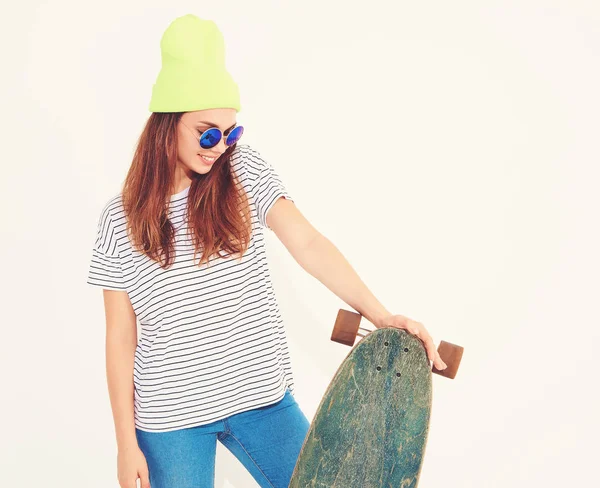 Portre rahat yaz giysileri longboard resepsiyon ile poz sarı beanie şapkalı şık kız modeli. Beyaz izole