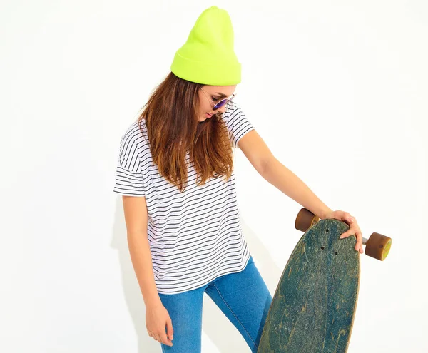 Portre rahat yaz giysileri longboard resepsiyon ile poz sarı beanie şapkalı şık kız modeli. Beyaz izole
