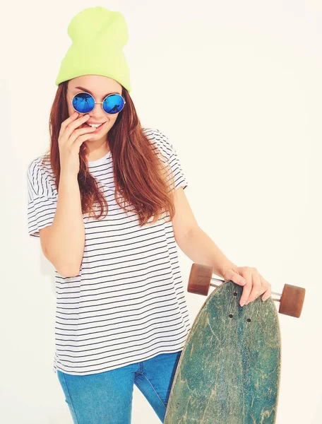 Portre rahat yaz giysileri longboard resepsiyon ile poz sarı beanie şapkalı şık kız modeli. Beyaz izole