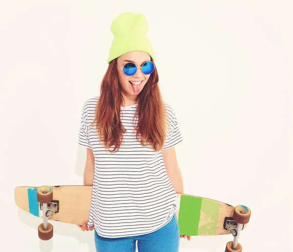 Portre rahat yaz giysileri longboard resepsiyon ile poz sarı beanie şapkalı şık kız modeli. Beyaz izole