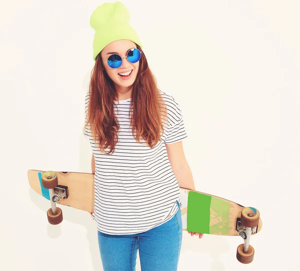 Portre rahat yaz giysileri longboard resepsiyon ile poz sarı beanie şapkalı şık kız modeli. Beyaz izole
