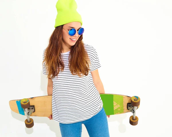 Portre rahat yaz giysileri longboard resepsiyon ile poz sarı beanie şapkalı şık kız modeli. Beyaz izole