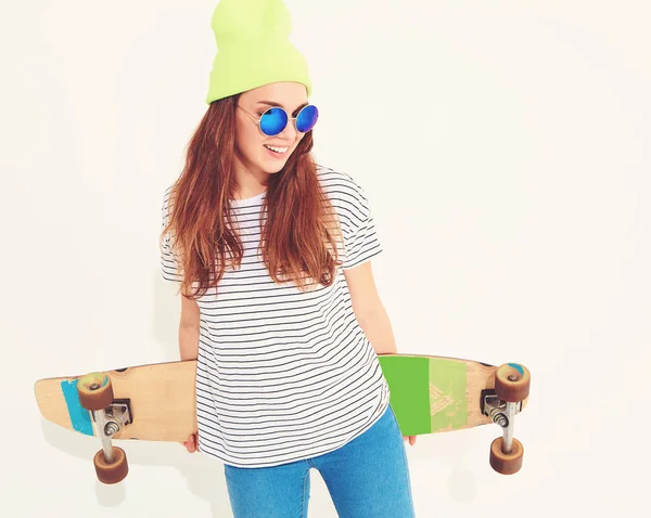 Portre rahat yaz giysileri longboard resepsiyon ile poz sarı beanie şapkalı şık kız modeli. Beyaz izole